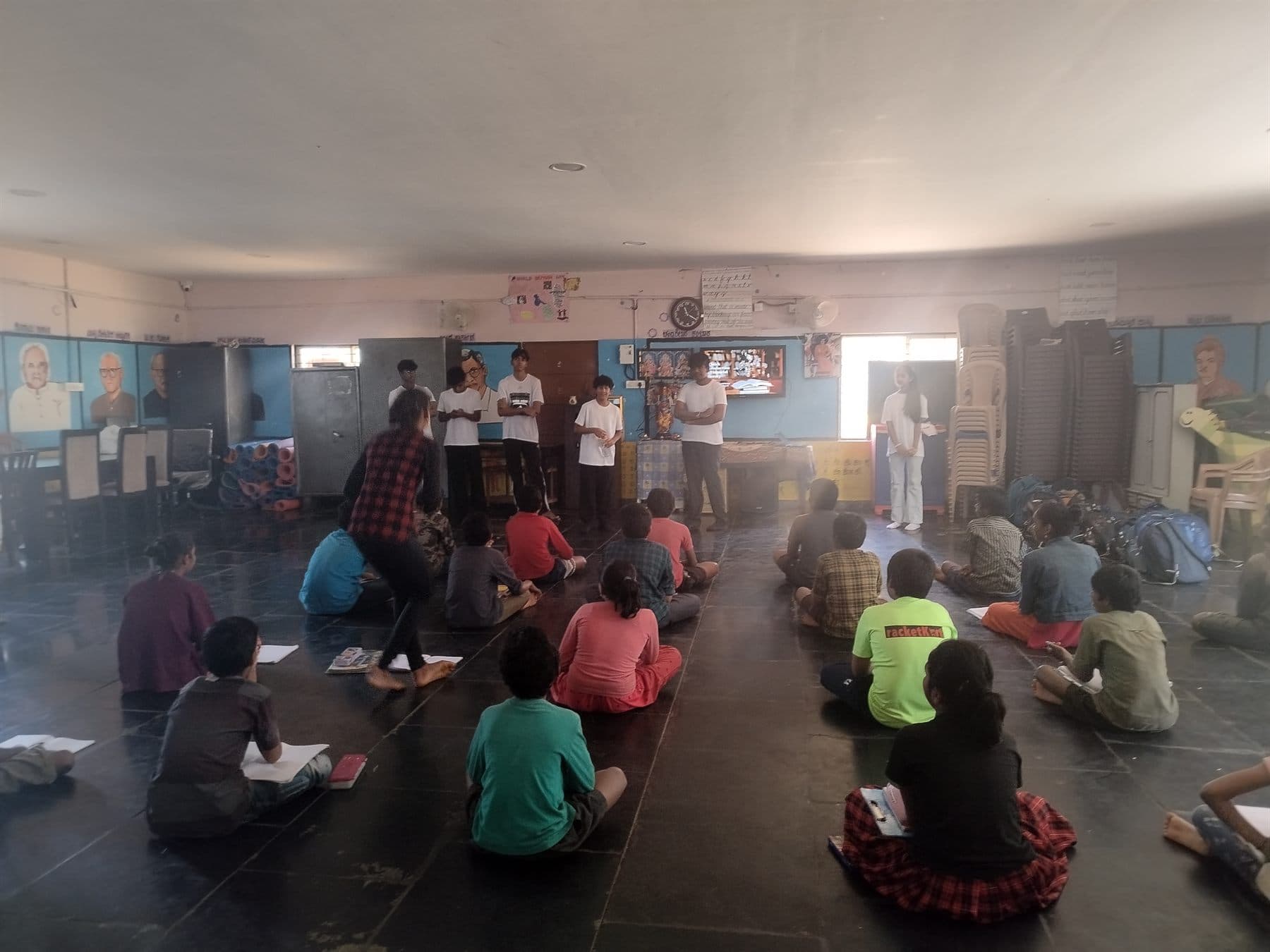 Finance For All volunteers addressing children seated on the floor at Ashirwad Sevaashrama